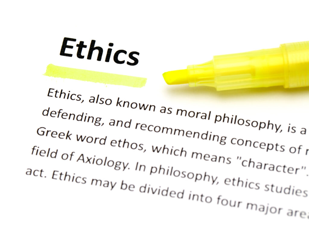 Ethics in einem Lexikon fett geschrieben und mit einem gelben Leuchtstift unterstrichen. Der Leuchtstift liegt neben dem unterschrichenen Wort