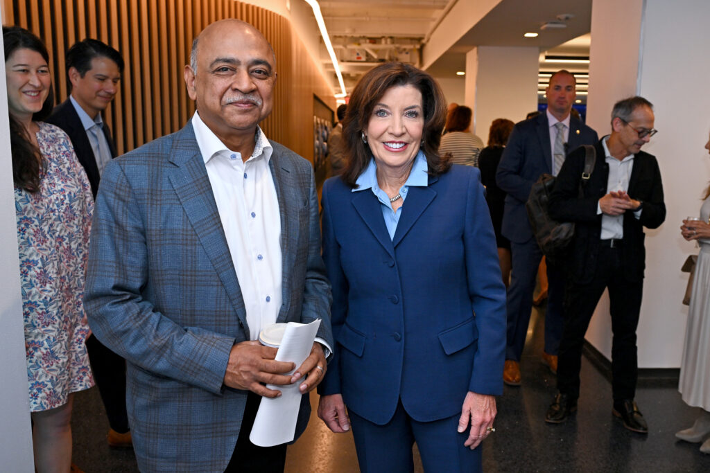 Arvind Krishna steht mit einer Frau in einem Gang mit Journalisten