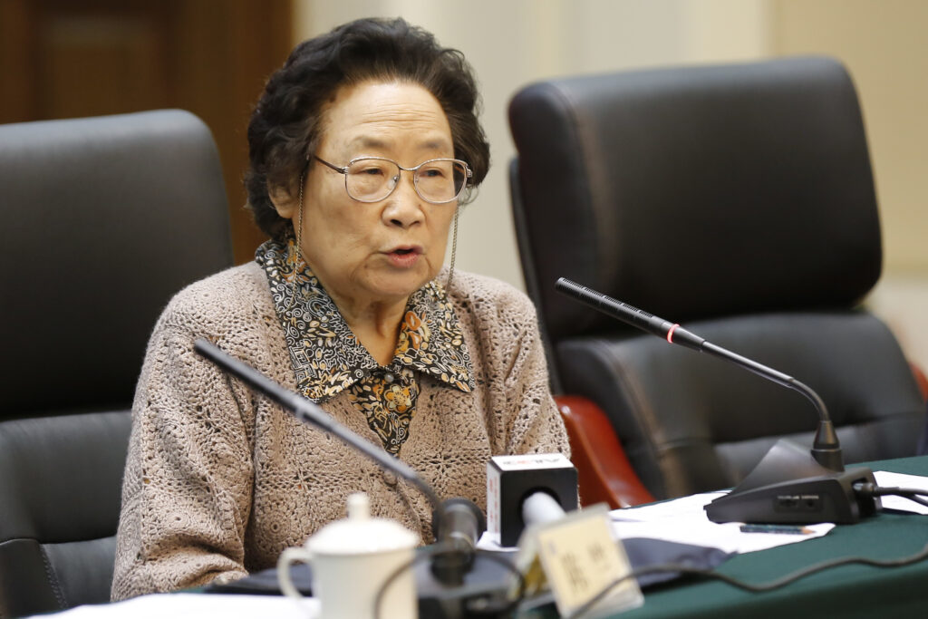 Tu Youyou trägt eine Brille und spricht in ein Mikrofon