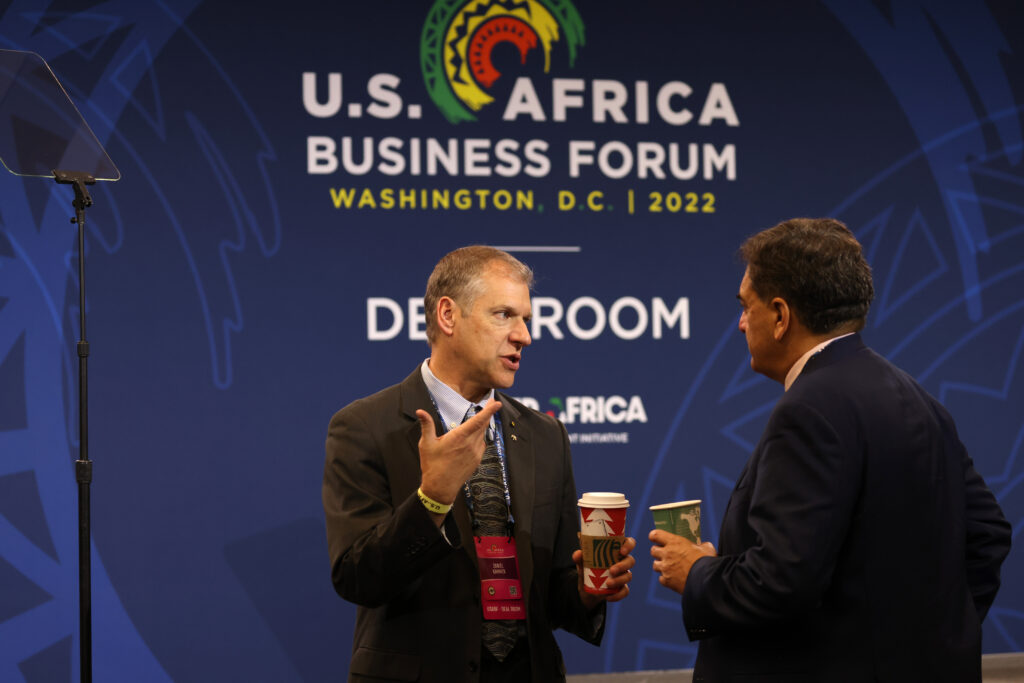 Daniel Kammen steht neben einem Mann vor einem Plakat U.S. Africa Business Forum