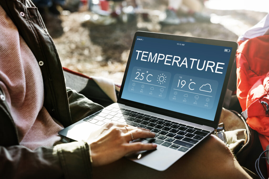 Notebook mit Temperature-Anzeige und eine Hand die darauf liegt