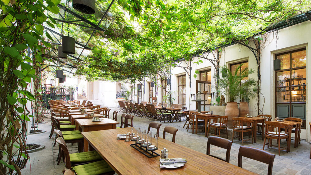 Begrünter Gastgarten der Gastwirtschaft im Durchhaus – Wiener Wirtshaus für Firmenfeiern, Geburtstagsfeiern und private Feiern.