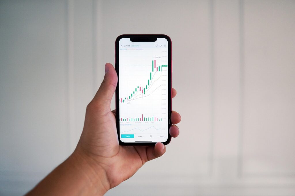 Ein Laptop und ein Smartphone mit abstrakten Kursverläufen symbolisieren die geplante Pre-IPO-Plattform von Revolut Ventures – Foto: TheInvestorPost / Pixabay