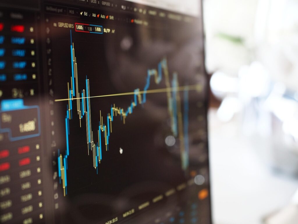 Ein Schreibtisch mit Chart-Bildschirmen und einem handschriftlichen Notizbuch veranschaulicht, wie ein Risikojournal das Trading-Risiko dokumentiert – Foto: Pexels / Pixabay