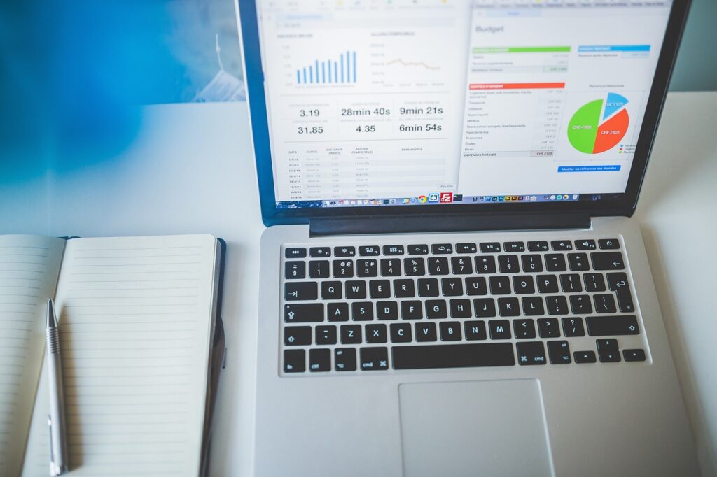 Ein Schreibtisch mit Laptop und Datenvisualisierungen symbolisiert die Forschung von Tanja Zweigle zur künstlichen Intelligenz in der Marktforschung – Foto: Pexels / Pixabay